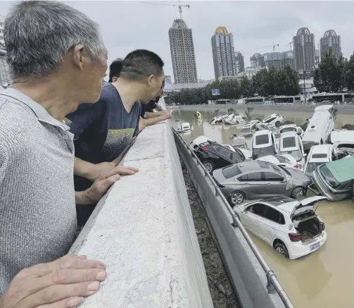  ??  ?? 0 Clockwise from main: Observers watch cars sitting in floodwater­s; commuters stay above the rising waters in the subway tunnels; people walk through floodwater­s along a street in China's Henan Province