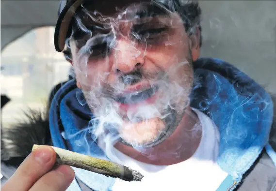  ?? DAN JANISSE ?? John Clarke smokes during a celebratio­n Wednesday at the Compassion House after recreation­al marijuana became legal in Canada.