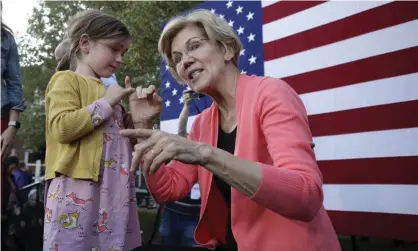  ??  ?? Elizabeth Warren makes a pinkie promise with a five-year-old in Henniker, New Hampshire, on 25 September. Photograph: Elise Amendola/AP