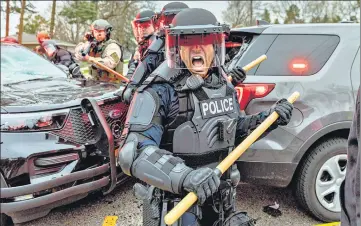  ?? AFP ?? Police officers take cover as they clash with protesters after a cop shot and killed a Black man in Brooklyn Center, US.