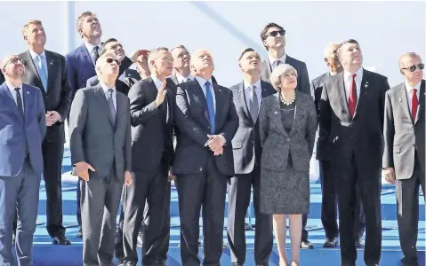  ??  ?? Algunos de los jefes de Estado y de gobierno de los países miembros de la OTAN observan el vuelo de un avión momentos antes de la toma de la fotografía oficial, durante la cumbre del organismo celebrada ayer en Bruselas, Bélgica.