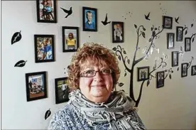  ?? JOSHUA A. BICKEL / DISPATCH ?? Mindy Atwood, CEO of Columbus-area nonprofit Patches of Light, stands near a wall of pictures of patients she has helped in the past two decades.