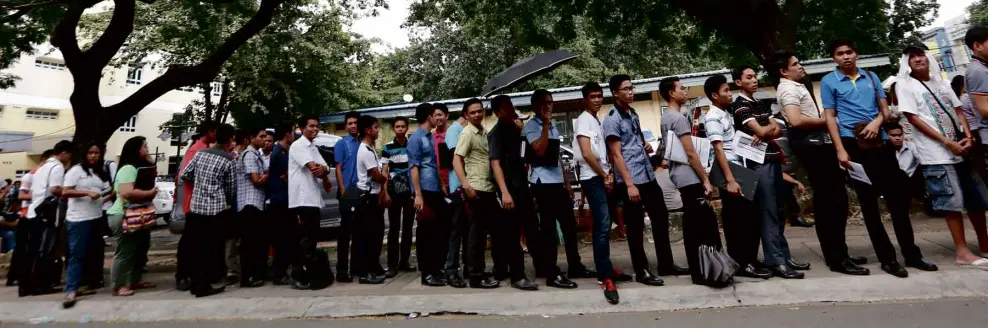  ??  ?? LAST HOUR, LONG QUEUE Voters line up at the Comelec office in Quezon City to beat today’s deadline for the registrati­on