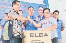  ?? ?? Linggu (left) with Stephen (centre) presenting the grand prize of the lucky draw to Star Karambunai members.