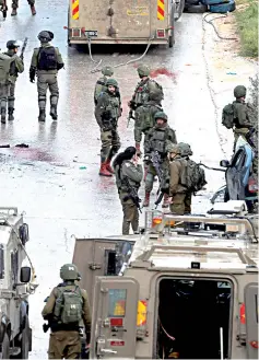  ??  ?? Israeli forces gather at the scene of the incident near Ramallah, in the Israeli-occupied West Bank. — Reuters photo