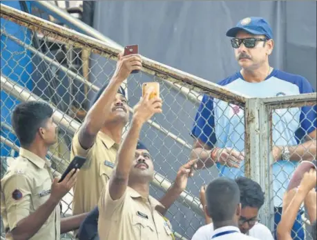  ??  ?? Police personnel take selfies with India cricket team coach Ravi Shastri ahead of the third T20 match against the West Indies, in Mumbai on Tuesday.
PTI