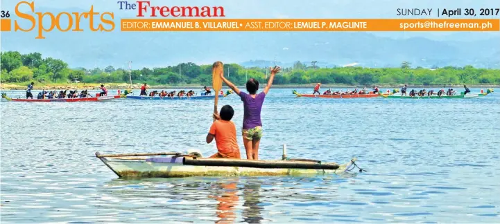  ??  ?? Two kids cheer on participan­ts of the 1st Cebu Dragon Boat Festival as they pass by their boat at the Mactan Channel on the first day of competitio­n.