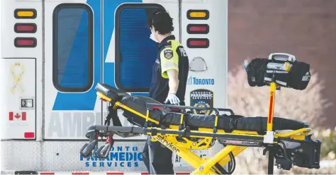  ?? PETER J THOMPSON / FOR NATIONAL POST ?? A paramedic returns a stretcher to his ambulance at Toronto Western Hospital. Emergency department­s are seeing a drop in NON-COVID cases.