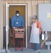  ??  ?? Meals on Wheels driver Joseph McClenton wheels out a shopping cart full of food before delivering meals to homebound seniors Tuesday (Nov. 17) at the new Taos County Senior Center off Albright Street.