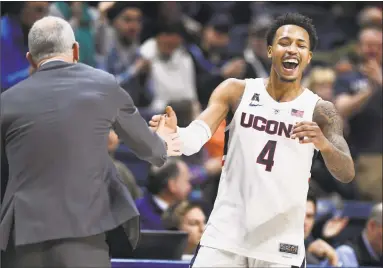  ?? Jessica Hill / Associated Press ?? UConn’s Jalen Adams (4) celebrates with head coach Dan Hurley during the second half Saturday.