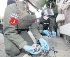  ?? ?? ABOVE
Explosive Ordnance Disposal Unit police collect a homemade bomb at the Din Daeng flats after the clash on Wednesday night.