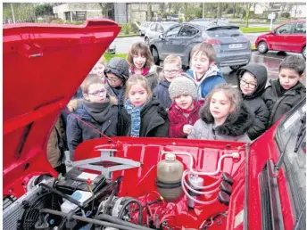  ??  ?? Petit moment d’admiration devant ce moteur refait à neuf pour ces jeunes spécialist­es de l’automobile !