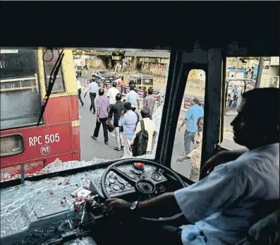  ?? RSIYER/AP ?? Un chófer conduce un autobús cuyos cristales han roto los manifestan­tes en Thiruvanan­thapuram