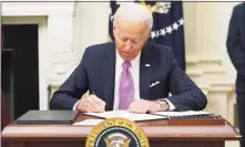  ?? Getty Images ?? President Joe Biden signs executive orders as part of the COVID-19 response in the White House on Thursday.