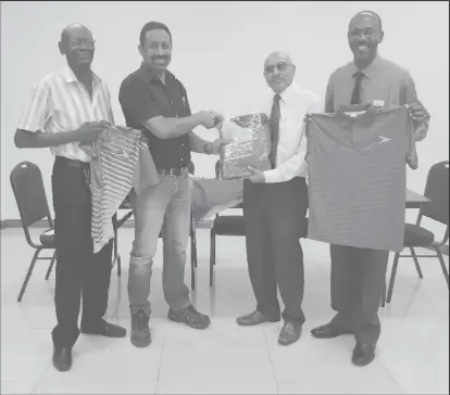  ??  ?? GOA President, K. A Juman Yassin (2nd right) hands over one of the track suits to Full-bore VC Dylan Fields in the presence of team members Ryan Sampson (right) and Ransford Goodluck.