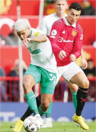  ?? AFP ?? Newcastle United’s Brazilian midfielder Bruno Guimaraes, left, fights for the ball with Manchester United’s Portuguese striker Cristiano Ronaldo during the English Premier League football match at Old Trafford in Manchester on Sunday.