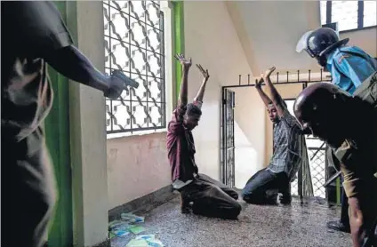  ?? Photo (above): Ivan Lieman/AFP ?? Surrenderi­ng to terror: Alleged jihadist youths are apprehende­d by police during a raid on the Masjid Mussa mosque in Mombasa, Kenya. Rogue policeman Abdihakim Maslah (left) shot dead seven of his colleagues after attempting to free an al-Shabab suspect.