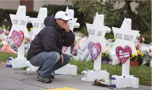  ?? PHOTO: REUTERS ?? Public grief: Tears are shed yesterday at a makeshift memorial to the victims of the massacre outside the Tree of Life synagogue in Pittsburgh.