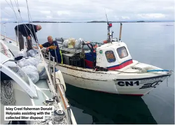  ??  ?? Islay Creel fisherman Donald Holyoaks assisting with the collected litter disposal