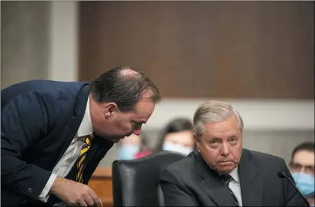  ?? CAROLINE BREHMAN/POOL VIA AP ?? Sen. Mike Lee, R-Utah, left, speaks with Chairman Lindsey Graham, R-S.C., during a Senate Judiciary Committee Executive Business meeting, including the nomination of Amy Coney Barrett to serve as an associate justice on the Supreme Court of the United States Oct. 22.