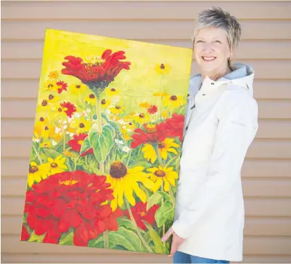  ?? BRANDON HARDER ?? Sherry Wolf, a volunteer with local charity Grandmothe­rs 4 Grandmothe­rs, holds a painting by Rose Steadman on Friday, one of the items to be auctioned off to raise funds for African grandmothe­rs who are raising children orphaned by AIDS.