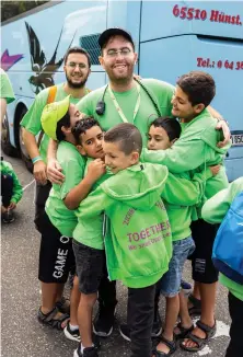  ?? ?? TZALI SUNRAY, organizer of the Zichron Menachem volunteers. gets hugs from the camp’s young participan­ts.