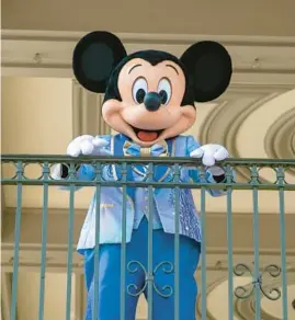  ?? TED SHAFFREY/AP 2022 ?? An actor dressed as Mickey Mouse greets visitors at Walt Disney World Resort in Florida. Mickey and Winnie the Pooh have recently entered the public domain.