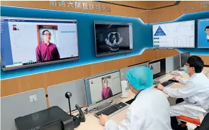  ??  ?? Le 8 mai 2020, un médecin de garde de l’hôpital Renmin n°6 de Nantong (Jiangsu) consulte un patient par liaison vidéo.