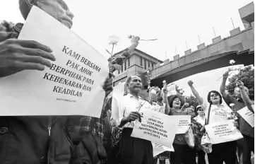  ??  ?? Supporters of Purnama hold a small rally outside the gate of the Mobile Police Brigade or Brimob headquarte­rs where he is being detained, in Depok, south of Jakarta, Indonesia. — Reuters photo