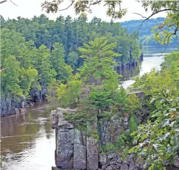  ?? CHELSEY LEWIS / MILWAUKEE JOURNAL SENTINEL ?? The St. Croix River cuts through a basalt gorge known as the Dalles of the St. Croix in St. Croix Falls. The dramatic rock walls are part of Interstate State Park — both on the Wisconsin and Minnesota sides of the river.