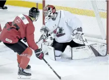  ?? NATHAN DENETTE/THE CANADIAN PRESS ?? Peterborou­gh Petes forward Jonathan Ang gets his shot stopped by U
Sports goalie Colton Point (1) during second period exhibition action at the Canadian national junior team selection in St. Catharines on Wednesday. Ang was cut from the selection camp...