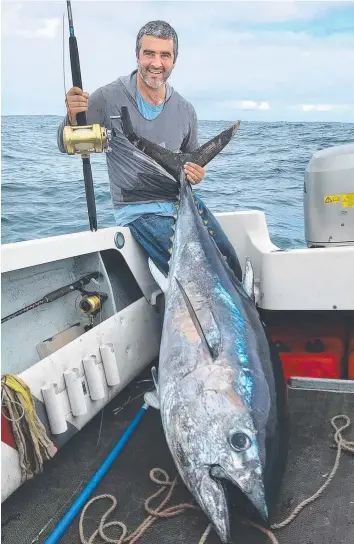  ?? Picture: ANDREW MCKENNA ?? WORTH THE TRIP: Connewarre angler Ben Bremmer, with the tuna he caught just offshore from Cape Bridgewate­r near Portland.