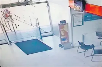 ??  ?? La imagen del circuito cerrado capta el momento en que la motociclet­a con los dos asaltantes a bordo sube la rampa para atropellar la puerta de vidrio de la sede bancaria.
