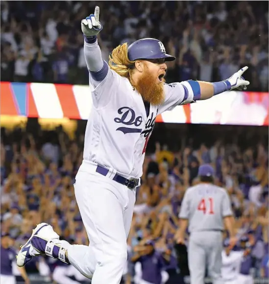  ?? Photograph­s by Wally Skalij Los Angeles Times ?? JUSTIN TURNER conjures memories of Kirk Gibson with his three-run, walk-off home run against John Lackey (41) of the Cubs in the ninth inning of Game 2.