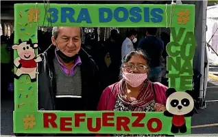  ?? AP ?? A couple pose for a photo holding a frame with the message ‘‘Third dose, get vaccinated, reinforcem­ent’’ during a Covid-19 vaccinatio­n campaign for people aged 60 and over in Mexico City.