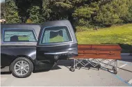  ?? Amy Osborne / Special to The Chronicle ?? A casket is removed from a hearse at Cypress Lawn. The huge Colma cemetery made a point of preparing for an increase, but others are overwhelme­d.