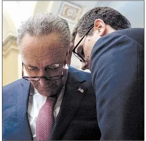  ?? AP/ANDREW HARNIK ?? Senate Minority Leader Charles Schumer (left) confers with an aide Tuesday on Capitol Hill. “We’re going to have to start on a new basis,” Schumer said.