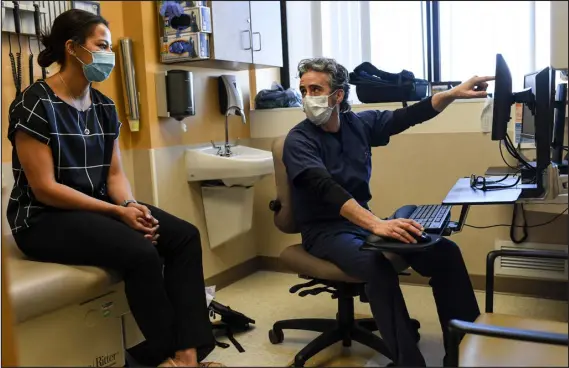  ?? AARON ONTIVEROZ — DENVER POST FILE ?? Pulmonolog­ist and critical care doctor Joshua Solomon speaks to medical student Candace Cephers before they meet with a patient at National Jewish Health in 2020.