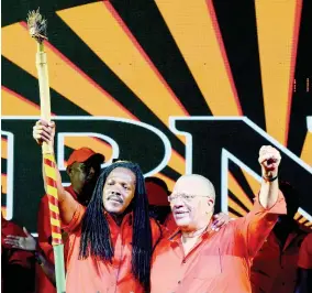  ?? ALLEN/PHOTOGRAPH­ER IAN ?? East Portland prospectiv­e candidate Damion Crawford, alongside PNP President Dr Peter Phillips, raises a rod handed to him by a Rastafaria­n in the partisan crowd at Port Antonio Square last night. Reprising charismati­c leader Michael Manley, Crawford made reference to the gift as “the rod of correction”.