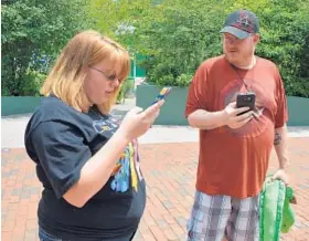  ?? BRITTANY BRITTO/BALTIMORE SUN ?? Allie and Daniel May hunt for Pokemon around the Inner Harbor. “It’s a layer on top of our real world,” said Allie May. “It’s insane. It adds another dimension.”