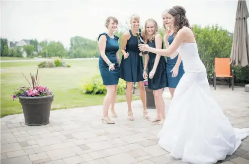  ??  ?? Bride-to-be Alyssa Cupido pops the cork on a bottle of champagne at her parents’ house in Calgary with bridesmaid­s, from left, Megan VanHuizen, Sanchia Rauch, Deanna Cupido and Amanda Duenk.