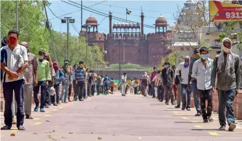  ?? PTI ?? SOCIAL DISTANCING: People queueing up to collect free food near Shish Ganj Gurudwara at Chandni Chowk in New Delhi during the nationwide lockdown to curb the spread of coronaviru­s on Sunday. —