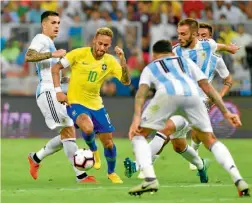  ??  ?? Jugadores albicelest­es aprietan a Neymar, en el duelo ante Brasil de octubre.