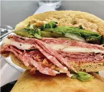  ?? Alison Cook / Staff ?? This sandwich du jour at Montrose Cheese & Wine had Genoa salami, provolone, farm greens, red pesto and pickled fennel.