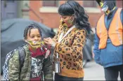  ?? ANDREW RUSH — PITTSBURGH POST-GAZETTE VIA AP, FILE ?? Jenea Edwards helps her son Elijah with his mask before heading into school on the first day of in-person learning via a hybrid schedule in Pittsburgh.