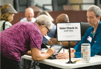  ?? LIZ DUFOUR/THE CINCINNATI ENQUIRER 2022 ?? A poll worker checks in a voter Aug. 2 during a primary election in Blue Ash, Ohio. A bipartisan effort among states to combat voter fraud has become the target of conspiracy theories about its purpose.