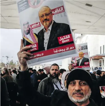  ?? — AP ?? A Turkish journalist holds a poster showing Saudi Crown Prince Muhammed bin Salman, left, and journalist Jamal Khashoggi, during funeral prayers for Khashoggi in Istanbul.