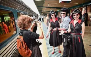  ??  ?? Fans in disguise: A woman taking a photo of people in costumes before boarding the train. — AFP