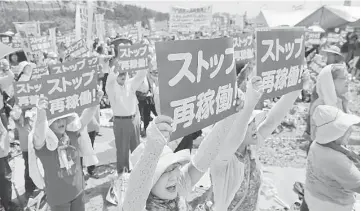  ??  ?? Anti-nuclear protesters holding a rally against the restart of a nuclear reactor in front of the Kyushu Electric Power Sendai nuclear power plant in Satsumasen­dai, Kagoshima prefecture, on Japan’s southern island of Kyushu.