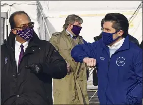  ?? Lori Van Buren / Times Union ?? Havidan Rodriguez, president of University at Albany, left, and Jim Malatras, chancellor of the State University of New York, bump elbows Friday after speaking at a news conference about the new COVID-19 vaccine site that opened at the University at Albany in Albany.